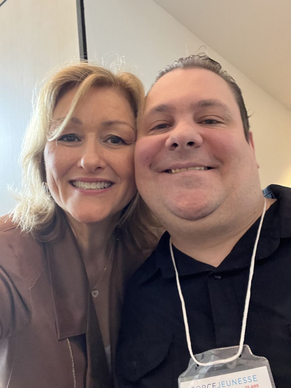 Une femme et un homme souriants prennent un égoportrait.