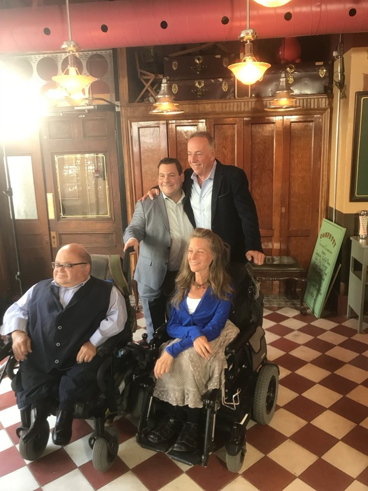Sur un plateau de tournage, Marc-André Laurier Thibault est entouré de deux hommes et de personnes en fauteuil roulant.