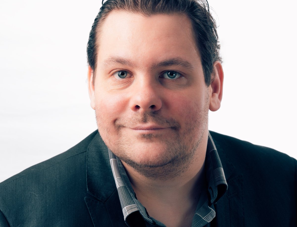 Portrait de Marc-André Laurier Thibault, souriant, en veston foncé.